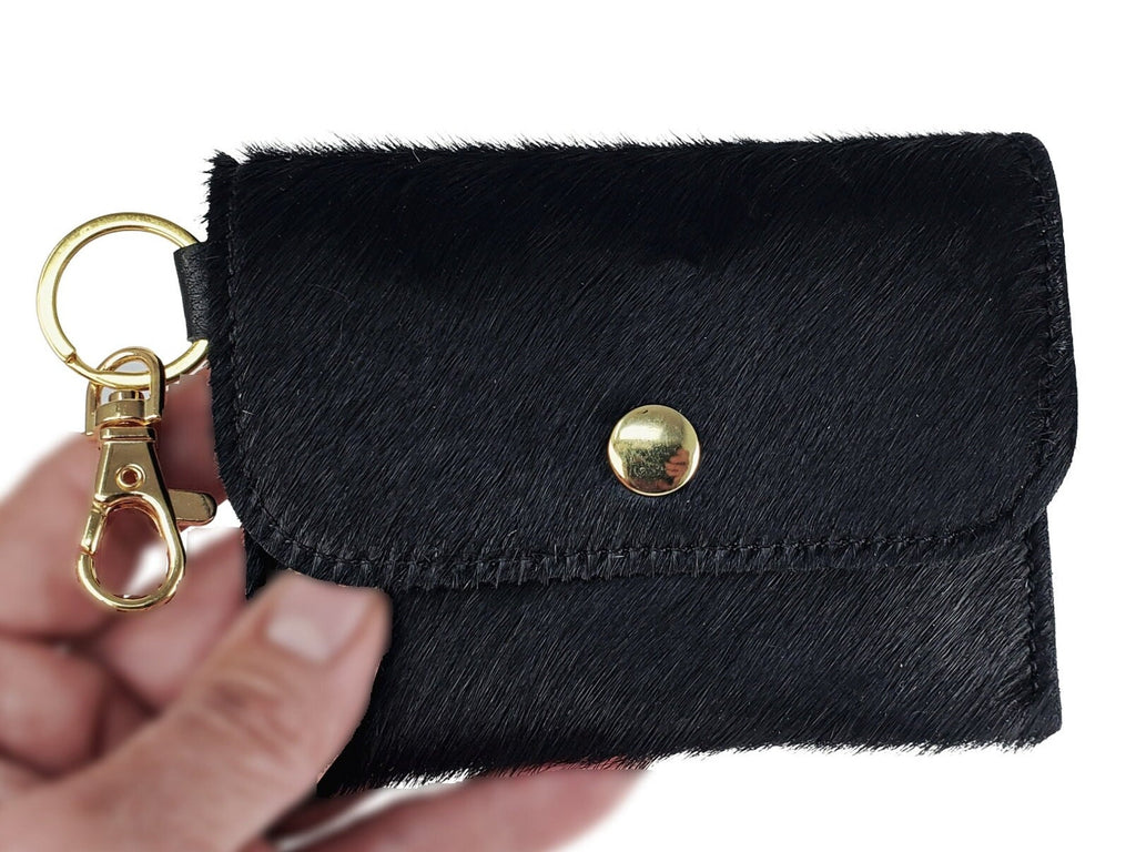 Black hair-on cowhide card wallet keychain with gold-tone snap closure and matching metal clip