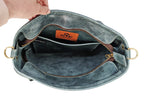Top-down view inside sage Madison leather tote showing unlined interior, zipper, slip pocket, and brass D-rings