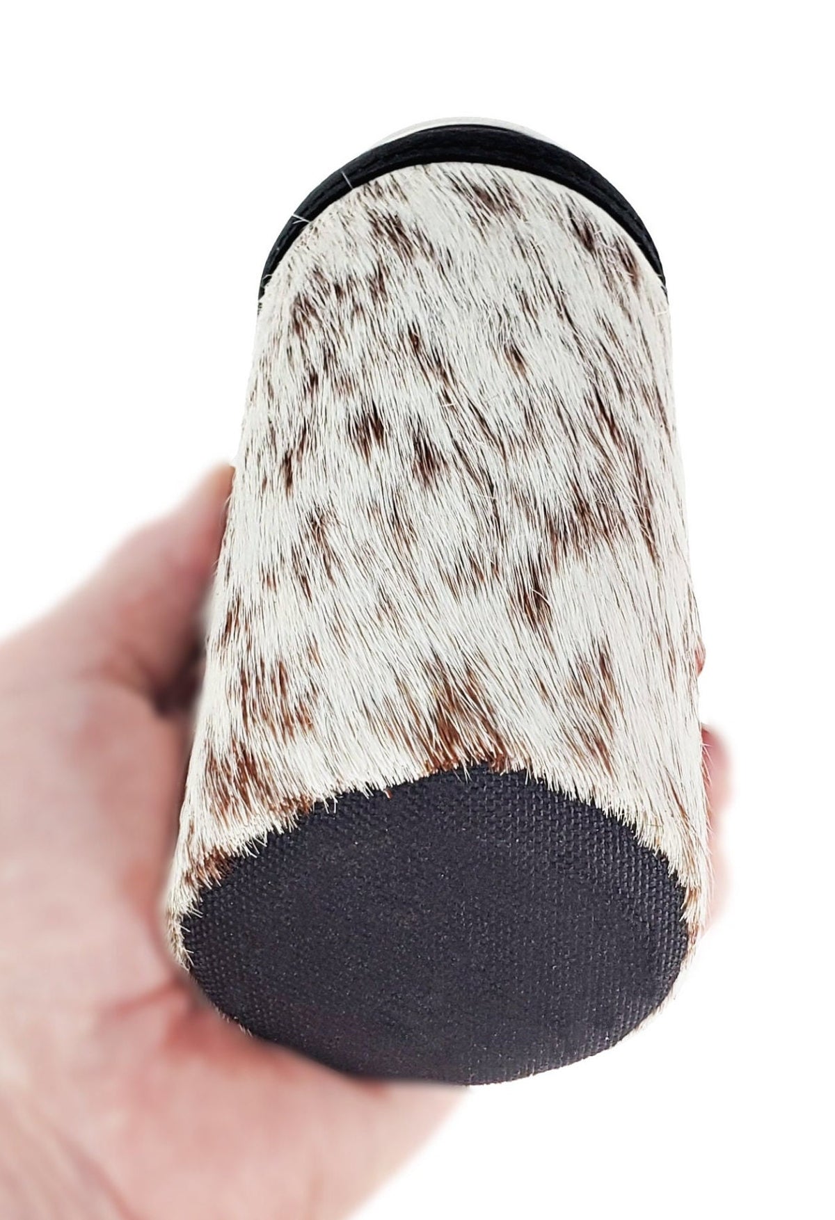 Bottom view of a hair-on cowhide slim can cooler showing its durable black ballistic nylon base