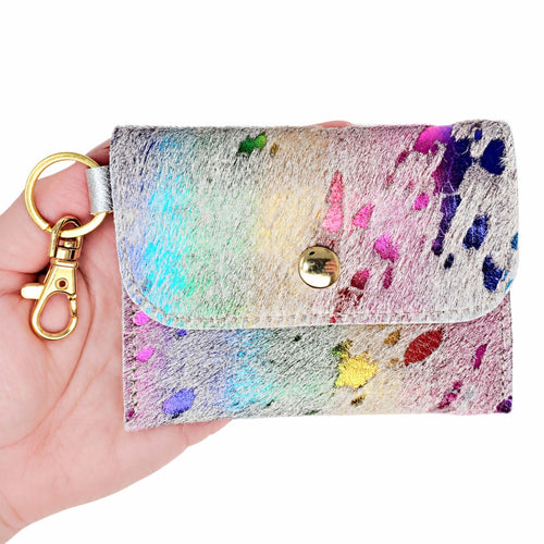 Hand holding a multicolored acid-wash cowhide keychain wallet with a gold-tone snap, key ring, and swivel clip