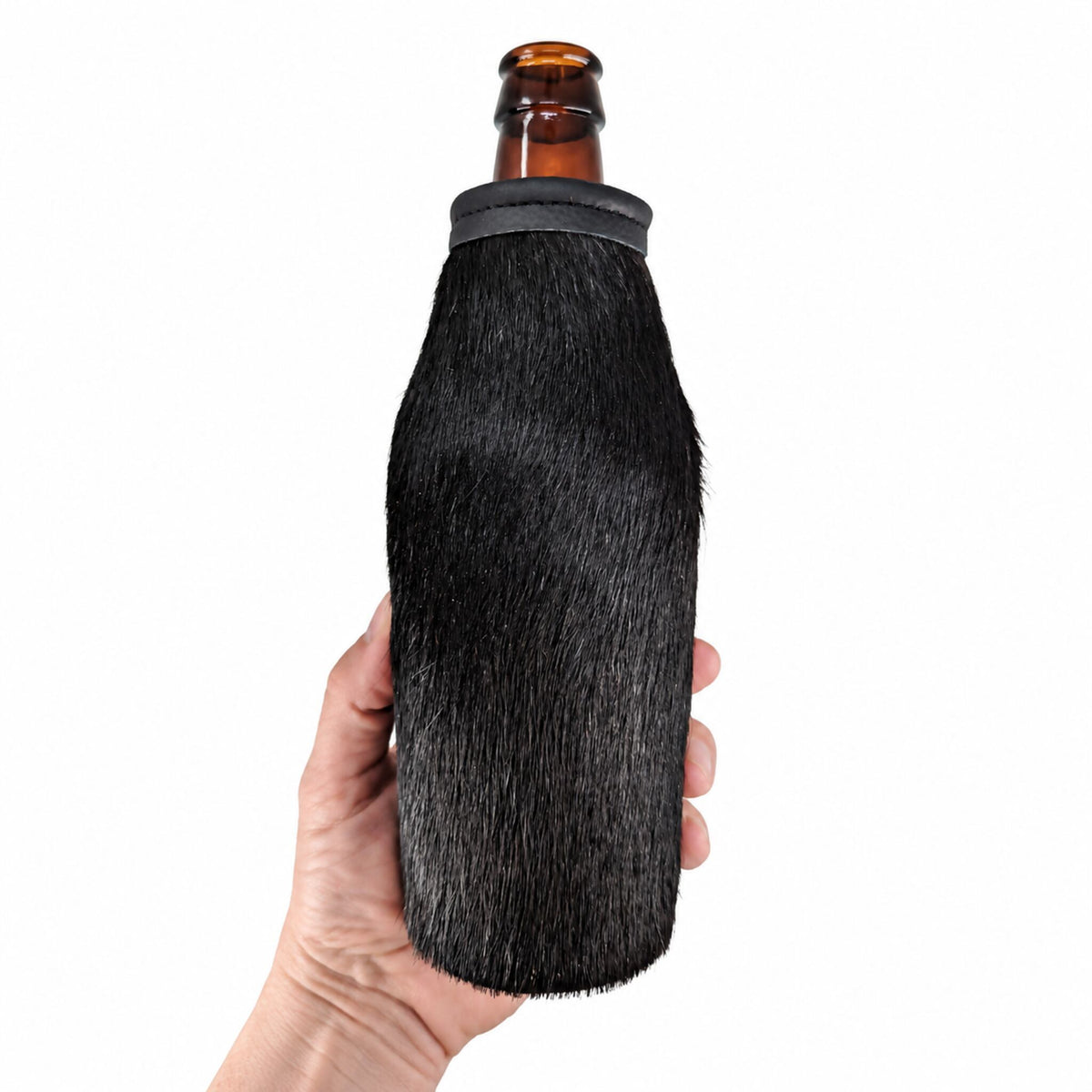 Black cowhide beer bottle holder shown in hand for scale