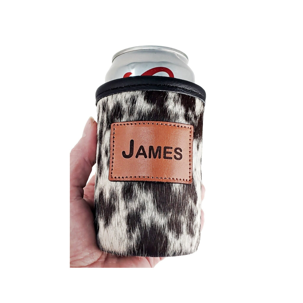 Black and white speckled cowhide can holder personalized with the name JAMES, shown in hand