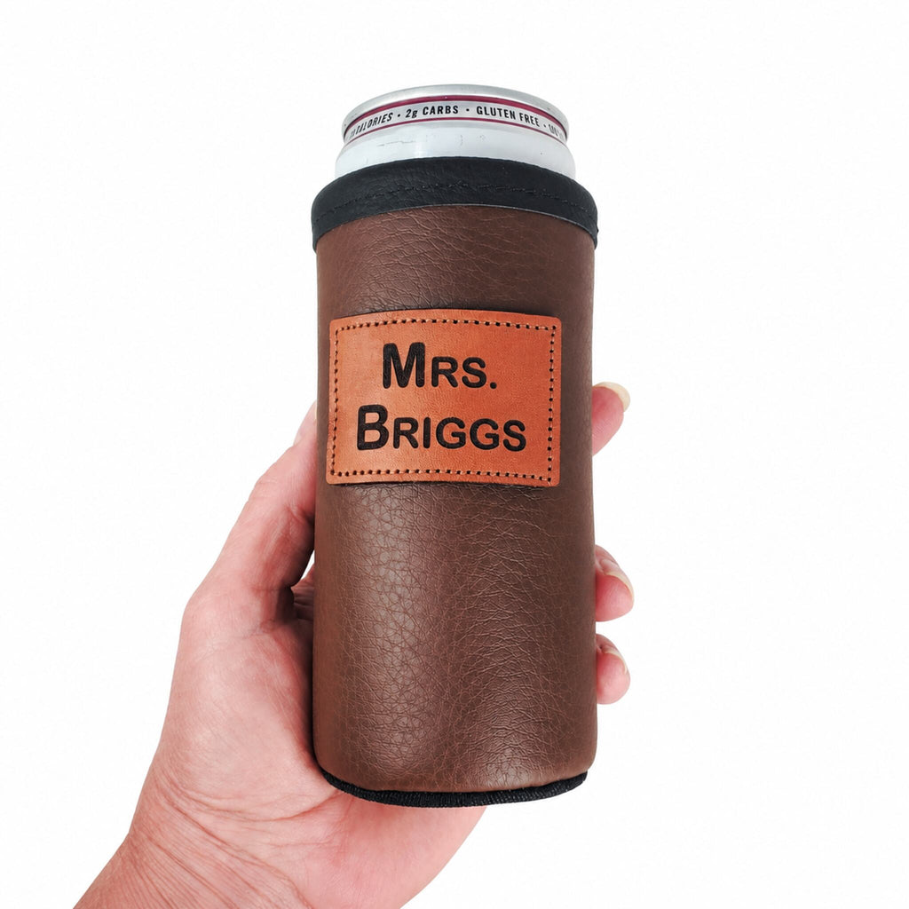 Brown personalized leather slim can holder shown in a hand for scale