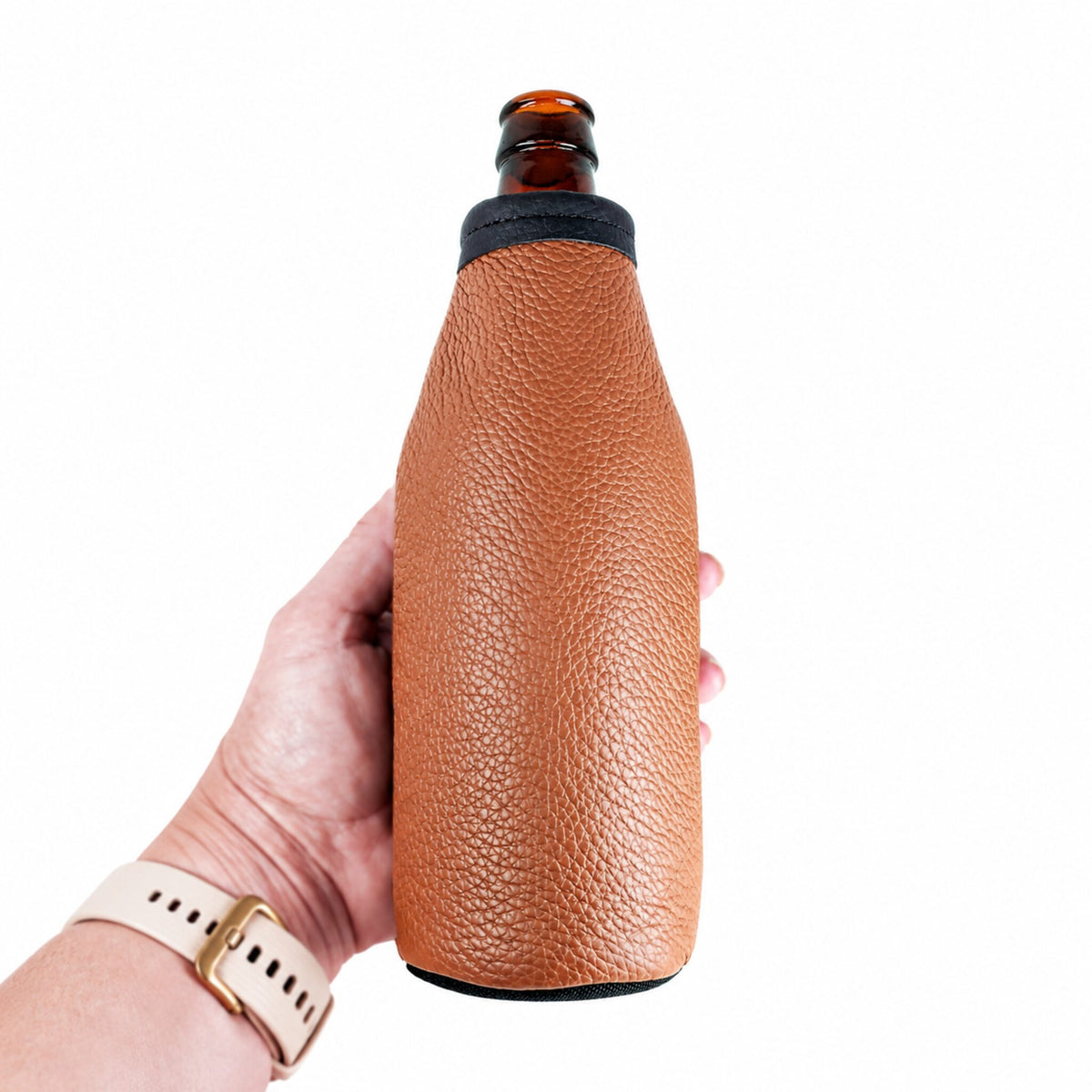 Hand holding a brown leather beer bottle holder on a standard long-neck bottle