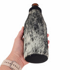 Speckled cowhide beer bottle holder shown from below with black ballistic nylon base