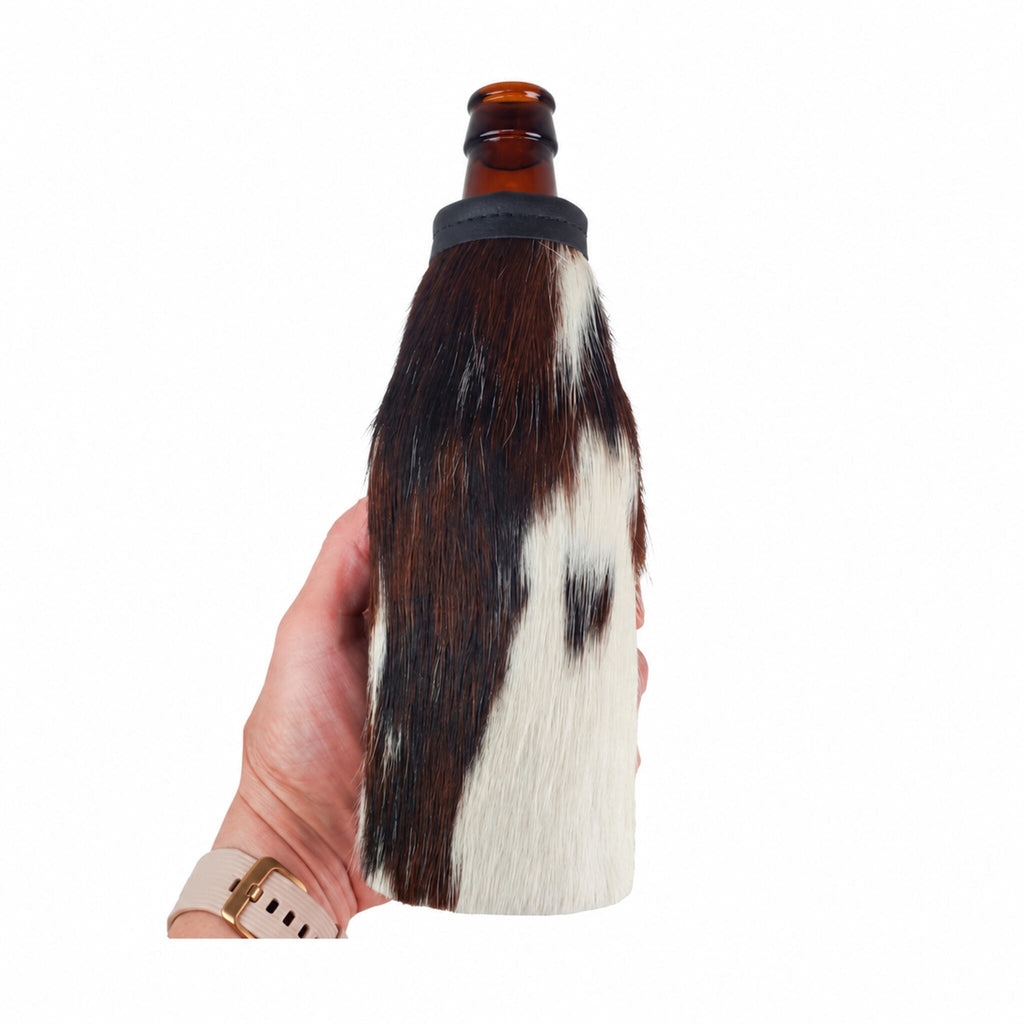 Tricolor cowhide beer bottle holder shown in hand for scale